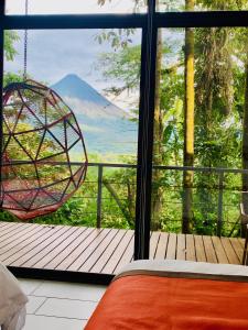 a bedroom with a view of a mountain through a window at Sangregado Lodge in Fortuna