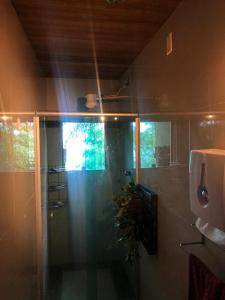 um chuveiro com uma porta de vidro na casa de banho em PACHAMAMA no Rio de Janeiro