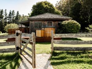 une clôture en bois devant une maison dans l'établissement Cedar Cottage Meander, à Meander
