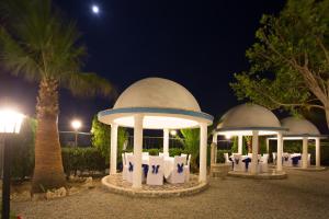 a group of gazebos at night with a palm tree at Residence Regina in Marina di Gioiosa Ionica +38 photos