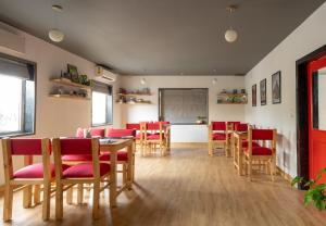 a dining room with red chairs and a table and a chalkboard at Loft 24, Mansarovar in Jaipur