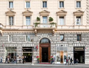 a building with people walking in front of it at Hotel Giolli Nazionale in Rome