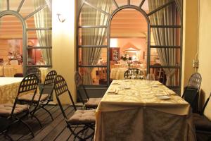 a dining room with a table and chairs and a mirror at Hotel Colonne in Varese