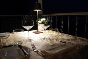 a table with three wine glasses and a plate on it at Hotel Colonne in Varese