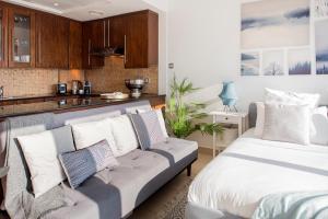 a living room with a couch and a kitchen at Nasma Luxury Stays - Charming And Fancy Studio In The Heart of Dubai in Dubai
