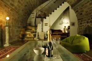 a table with a bottle of wine and glasses on it at La Demeure du Lac de Fugeres in Le Puy en Velay