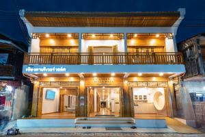 清刊Chiangkhan River Walk Hotel的前面的商店,前面有长凳