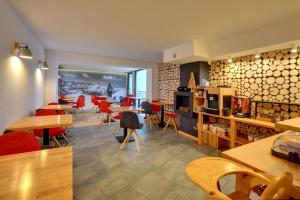 a restaurant with tables and red chairs and a room at Dom Górski in Karpacz