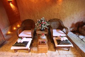 Zimmer mit 3 Stühlen, einem Tisch und einem Kamin in der Unterkunft The Hotel by the Red Canal in Mandalay
