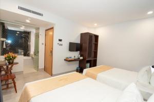 a hotel room with two beds and a bathroom at La Casa Tuy Hòa in Tuy Hoa