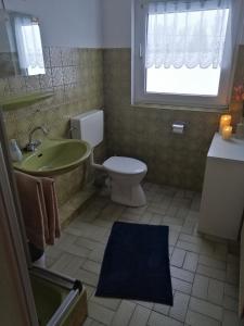 a bathroom with a toilet and a sink and a window at Haus Valentin in Dornum