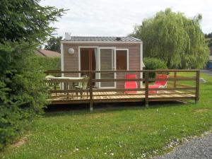 Cabaña con 2 sillas rojas en una terraza en camping aire du gros pré, en Lesseux