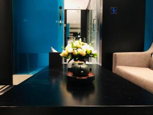 eine Vase mit Blumen auf einem Tisch im Wohnzimmer in der Unterkunft Likto Hotel-Free Shuttle Bus to Canton Fair in Guangzhou