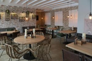 a restaurant with tables and chairs in a room at Barrels am Clerve in Enscherange