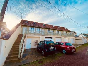 two cars parked in front of a house at La Cabourgeaise in Cabourg