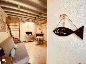 a living room with a sign hanging on the wall at La Cabourgeaise in Cabourg