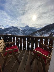 two chairs on a deck with a view of mountains at Auberge De La Forêt - Hôtel in Auris +16 photos