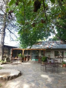 a building with tables and chairs in front of it at Autumn Breeze Manor Guest House in Graskop