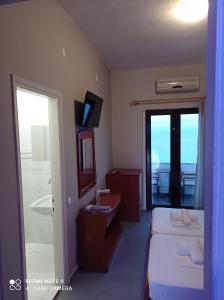 een hotelkamer met een bed en een badkamer met een raam bij GR Apartments Sea View in Kallithea