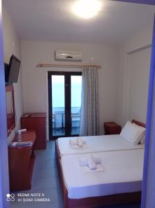 um quarto de hotel com uma cama e uma janela em GR Apartments Sea View em Kallithea Halkidikis