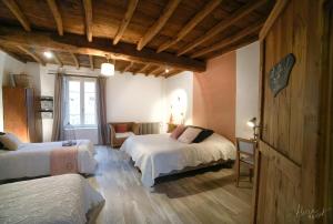 a bedroom with two beds and a chair in a room at Les Tilleuls in Saint-Jean-dÊ¼Avelanne