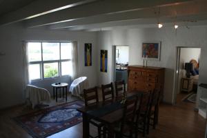 a dining room with a table and chairs and a kitchen at Rolsø Retreat - the apartment in Knebel