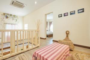 a living room with a staircase and a rug at Talay Hotel and Villa Cha-am in Cha Am