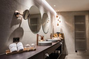 La salle de bains est pourvue de 2 lavabos et de 2 miroirs. dans l'établissement Prunner Luxury Suites - Adults Only, à Schenna