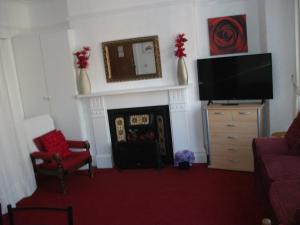 a living room with a tv and a fireplace at Lawnswood Holiday Apartments in Blackpool