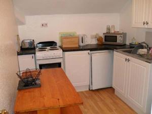 a kitchen with white appliances and a wooden table at Lawnswood Holiday Apartments in Blackpool