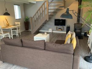 een woonkamer met een bank en een trap bij Bed & breakfast Heitse in Heythuysen