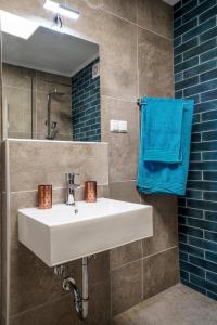 een badkamer met een witte wastafel en een blauwe handdoek bij Dimitra Beach Apartments - Nea Karvali Kavala in Néa Karváli