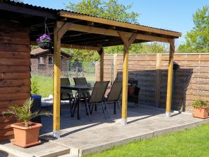 a wooden pergola with a table and chairs on a deck at Ferienoase Hattorf in Hattorf