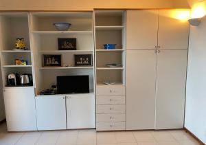 a large white closet with white cabinets and a television at Punta Est - Mono OSTRO Terrazza Fronte Mare in San Teodoro