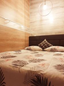 a bedroom with a large bed with a wooden wall at INN Royal House #1 in Brest