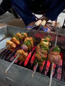 a person is cooking food on a grill at SERENITY CAMPS, MUSSOURIE in Mussoorie