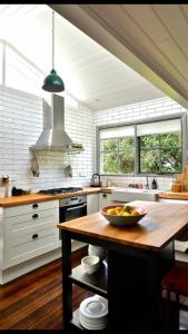 a kitchen with a bowl of fruit on a wooden table at Waterside Cottage in Daylesford