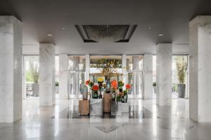 eine Lobby mit einer Blumenvase in einem Gebäude in der Unterkunft Dusit Thani LakeView Cairo in Kairo