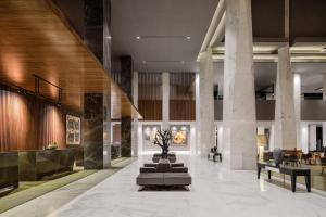 a lobby of a hotel with a staircase and tables at Dusit Thani LakeView Cairo in Cairo