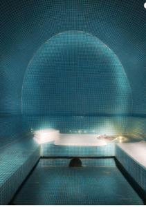 a blue tiled bathroom with a tub and a sink at Zan Hotel in Voineasa