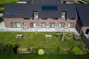 an aerial view of a building with a yard with benches at B&B 't Goedhof in Maaseik