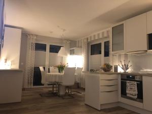 a kitchen with white cabinets and a table and chairs at Strandstraße H3W6 Kölpinsee in Loddin