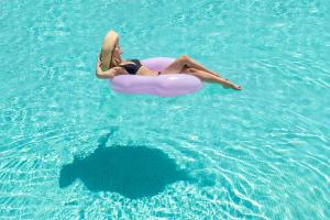 a woman is laying on an inner tube in the water at Santa Irina Luxury Sunny Lofts in Perivolos