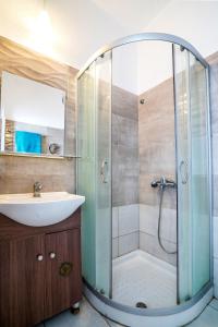 a bathroom with a glass shower and a sink at Dimitra Beach Apartments - Nea Karvali Kavala in Nea Karvali