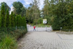 ヴィスワにあるApartament Na Urlop - Wisła Bukowa 6 - 650m do deptaka spacerowego w centrum Wisłyの公園内の柵を通り過ぎた者
