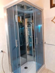 y baño con ducha y puertas de cristal. en Green House en Villaputzu