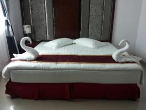 ein Bett mit zwei Schwänen darüber in der Unterkunft Horizon Hotel Apartments - الأفق للشقق الفندقية in Al Khawḑ