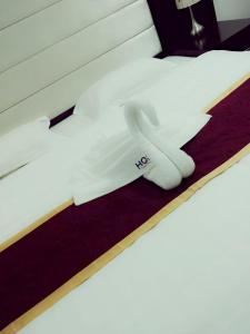 a pair of white gloves sitting on top of a bed at Horizon Hotel Apartments - الأفق للشقق الفندقية in Al Khawḑ