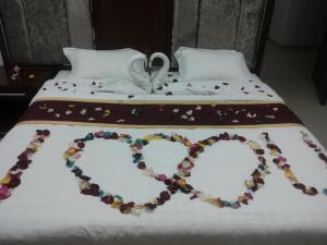 een bed met een hart gemaakt van koekjes bij Horizon Hotel Apartments - الأفق للشقق الفندقية in Al Khawḑ