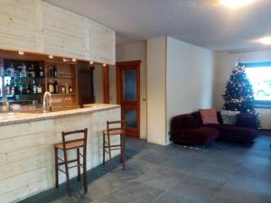 a bar with two chairs and a christmas tree in a room at Hotel Sciatori in Sestriere